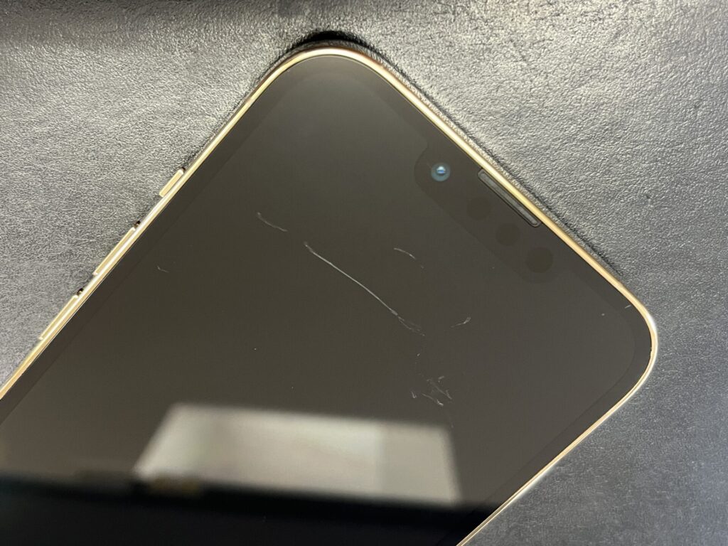 iPhoneの液晶に爪にかかる程の傷がある写真です。