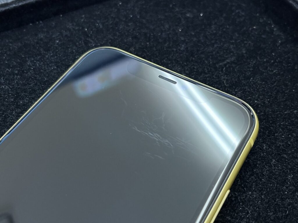 iPhoneの液晶広範囲に擦れによる傷がある写真です。